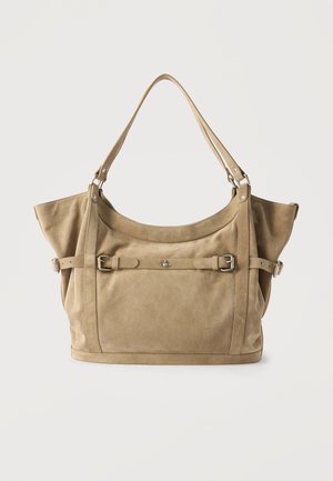 Sac à main en daim beige avec une large bandoulière, une boucle décorative à l'avant, et des côtés structurés légèrement évasés sur un fond clair uni.