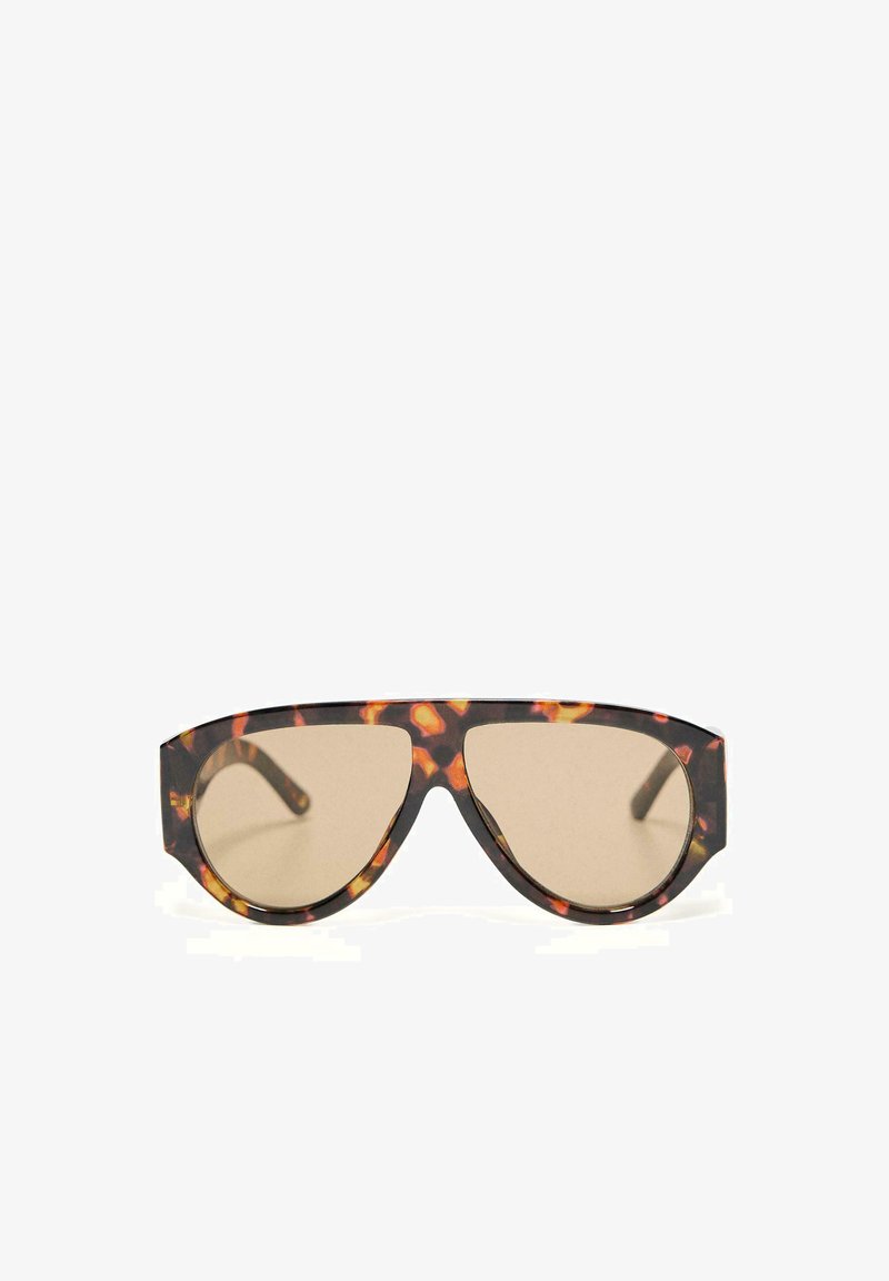 Occhiali da sole oversize con montatura ampia e motivo tartarugato, con lenti color beige, mostrati su sfondo bianco.