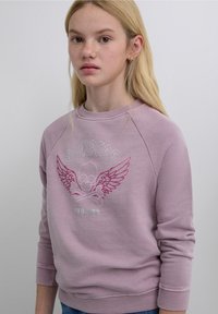 Sudadera lavanda con mangas raglán, con un gráfico de una calavera con alas y huesos cruzados bordados en rosa y plata.
