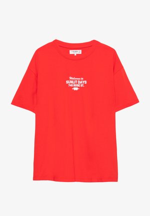 Élénk vörös pamut póló, rövid ujjakkal és kerek nyakkivágással, fehér felirattal: "Üdvözöljük a SUNLIT DAYS-nél, 745 ROSE ST."