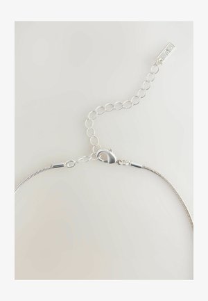 Sudraba kaklarota ar čūskas ķēdi un omālu sprādzi, pielāgojamas garuma ķēdi un savstarpēji savienotiem apļa posmiem.