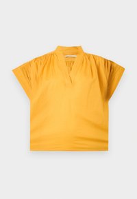 Blouse jaune à manches courtes avec un col en V, épaules froncées et un petit col montant, posée à plat sur un fond clair.