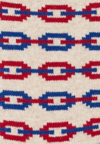 Tessuto lavorato a maglia con un motivo ripetuto di ovali interconnessi rossi e blu su uno sfondo crema, evidenziando la sua texture e il contrasto di colori.