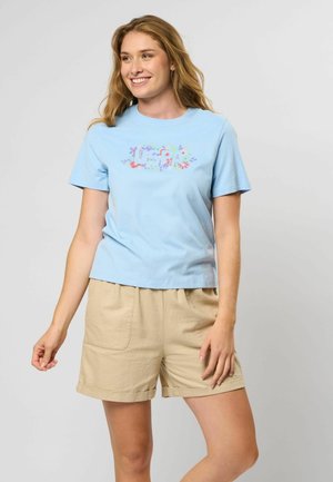 Blå bomulls T-skjorte med et fargerikt blomstertrykk på forsiden, sammen med beige shorts med sidelommer og oppbrettede ermer.