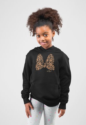 Svart huvtröja med en stor grafisk leopardskrivbåge. Modellen har på sig grå leggings med färgglada prickar.