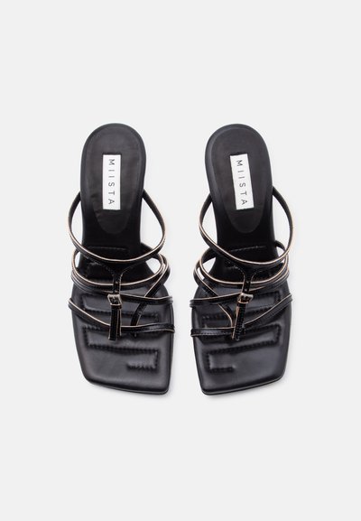 Μαύρα πλατφόρμα σανδάλια με λουράκια, με τετράγωνες μύτες και λεπτά ρυθμιζόμενα λουριά γύρω από τον αστράγαλο, με την επωνυμία MIISTA στη σόλα, τοποθετημένα σε λευκό φόντο.