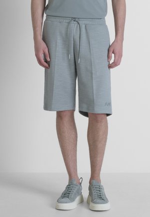 Shorts gris clair en tissu texturé, dotés d'une taille élastique avec cordon de serrage, de poches latérales et d'un accent logo sur l'ourlet.