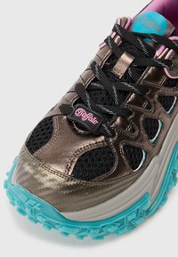 Sapatilha metálica castanha com um upper de malha preta texturizada, detalhes em rosa e teal, sola grossa azul clara e atacadores pretos.