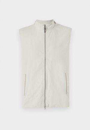 Lettvekts uten ermer vest i krem, med høy krage, frontglidelås og to sidelommer med subtle gyldne aksenter.
