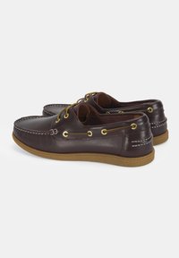Braune Lederbootsschuhe mit niedrigem Profil, runder Spitze und goldenen Ösen. Verfügt über Kontrastnähte und eine strukturierte Gummisohle.