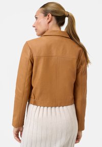 Brun læderjakke med en cropped design, der har en kraveudskæring og elastisk talje. Glat tekstur med minimale syning detaljer.