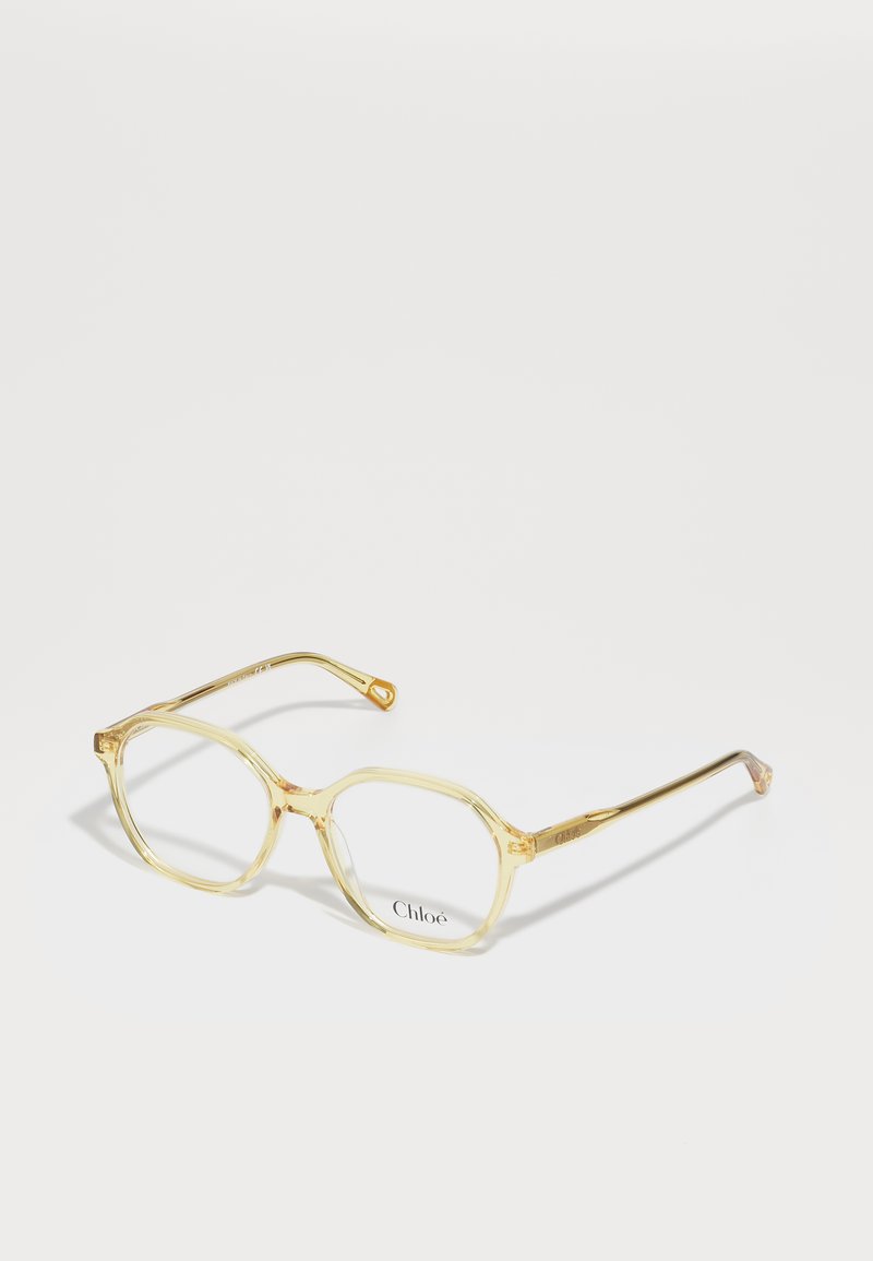 Montature per occhiali trasparenti gialli in acrilico con forma ottagonale, dotate di aste in metallo color oro e logo "Chloé" sulle lenti.