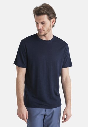 Camiseta de manga corta azul marino, cuello redondo, hecha de un material texturizado, con corte ajustado, bordes limpios y diseño minimalista.