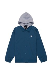 Tyrkysový vonkajší kabát s sivou kapucňou, vybavený gombíkmi, elastickými manžetami a logom na ľavej strane hrudníka. Vyrobený z hladkého, ľahkého materiálu.