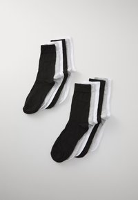 Sæt med otte sokker i sort, hvid og grå. Stof er glat med en ribbet tekstur ved kanten. Ingen mønstre eller hardware til stede.