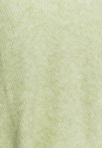 Ljust grönt texturerat tyg med en mjuk, något ludden yta, som har ett subtilt mönster av sammanflätade trådar.