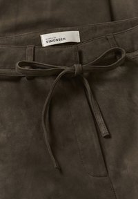 Bruine suède broeken met een gestrikte tailleband en een label met de tekst "KAREN BY SIMONSEN." De textuur is zacht met een gladde afwerking.