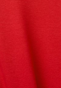 Red fabric with a smooth texture, featuring a fine ribbed pattern. Material appears lightweight and suitable for casual wear.