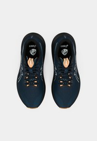 Chaussures de sport bleu foncé avec une tige en mesh respirant, semelle en caoutchouc noire, accents orange et fermeture à lacets. Présente un logo sur la languette.