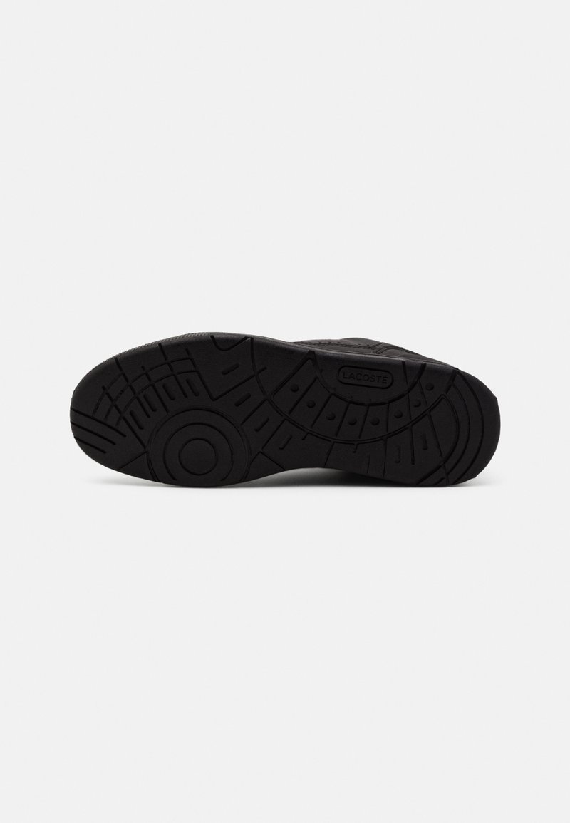 Black rubber sneaker sole with multi-directional tread patterns. Features the brand logo embossed on the side. Smooth texture overall.