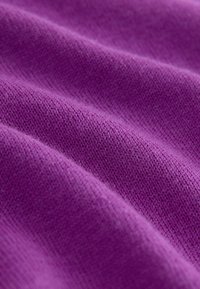 Purple knit fabric with a soft texture, displaying a smooth surface and subtle variations in shade, folded in gentle waves.