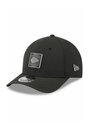Zwarte baseballpet met gebogen klep, met een grijs Kansas City Chiefs-logo patch aan de voorkant en een New Era-logo aan de zijkant.