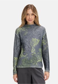 Der gestrickte Pullover zeichnet sich durch eine Mischung aus grauen und lebhaft grünen Paisleymustern aus. Hoher Halskragen und gerippte Bündchen mit einer strukturierten Oberfläche.
