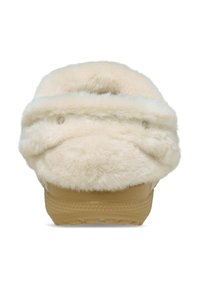 Pantuflas esponjosas de color crema con una textura suave, presentan un upper de piel de foca gruesa y una suela de goma color marrón con pequeños agujeros de drenaje.