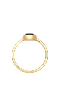 Anello d'oro con una fascia liscia e una pietra preziosa nera rotonda montata in modo prominente. Design semplice che si concentra sui colori e sulle forme in contrasto.