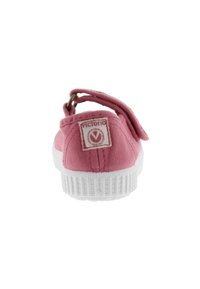 Zapatilla infantil de lona rosa con suela de goma blanca, correa ajustable y etiqueta de la marca "victoria" en el talón.