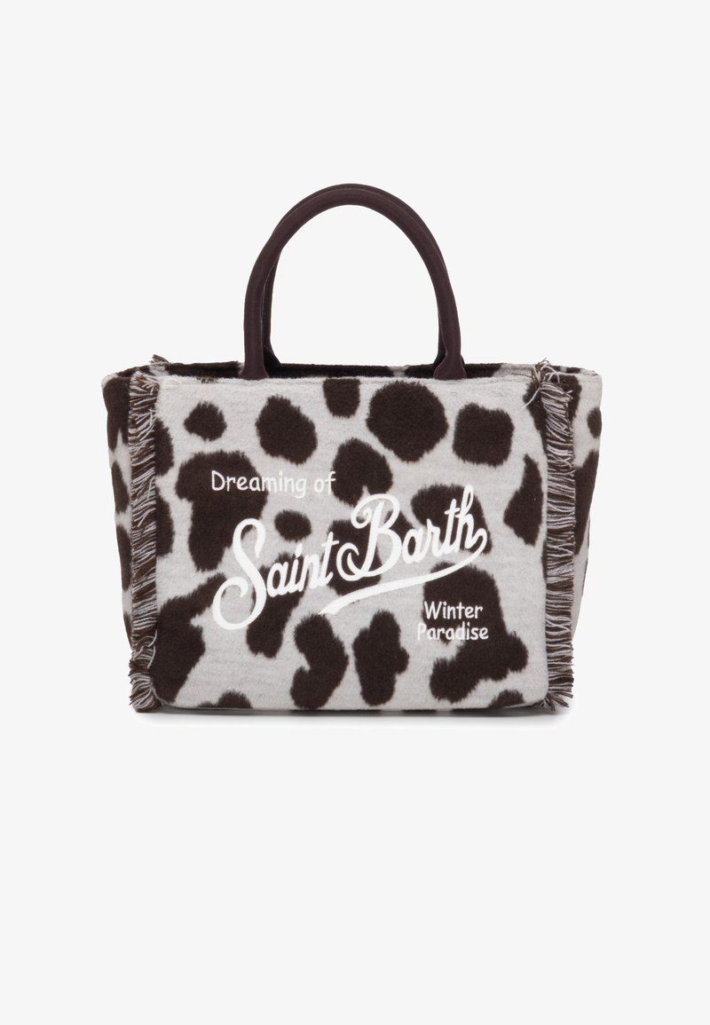 Sac en toile gris avec motif de vache marron foncé, présentant des ornements en franges et un texte blanc qui dit "Rêvant du paradis d'hiver de Saint Barth."