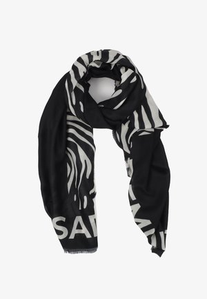 Czarny i biały szalik w wzór zebry, wykonany z miękkiego, lekkiego materiału, z frędzlami na krawędziach. Duży tekst na dole.