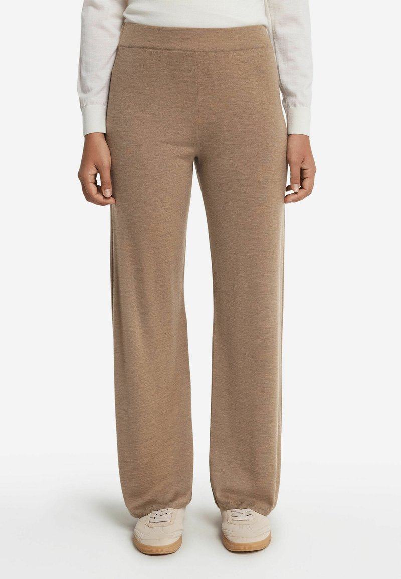 Brique brede broek gemaakt van een zachte, textuurstof. De tailleband is elastisch en ze worden gecombineerd met lichtgekleurde sneakers.