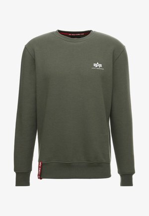 Sweatshirt verde com mangas longas, gola redonda, punhos e bainha canelados. Apresenta um pequeno logotipo branco no peito e uma etiqueta vermelha na lateral.