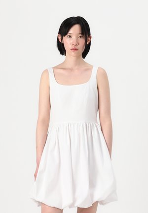 Vestido blanco sin mangas con escote cuadrado, corsé ajustado y falda acampanada y fruncida. El material parece suave con una ligera textura.