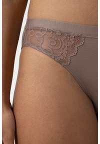 Braune Panties mit transparenten Spitze-Details an der Seite, die ein Blumenmuster aufweisen. Weicher Stoff, glatte Kanten, entworfen für Komfort.