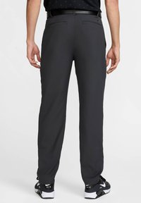 Dark grey athletic pants with a smooth fabric texture, straight-leg design, two back pockets, and paired with black and white sneakers.