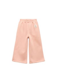 Jasnoróżowe, szerokie spodnie dresowe z elastycznym pasem i małą metką z logo. Miękka tkanina o gładkiej strukturze, bez wzoru ani akcentów.