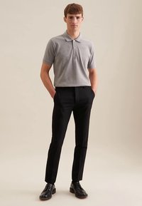 Graues Polohemd mit kurzen Ärmeln, schwarze Hose und schwarze Schuhe. Das Polohemd hat einen Kragen und ein minimalistisches Design.