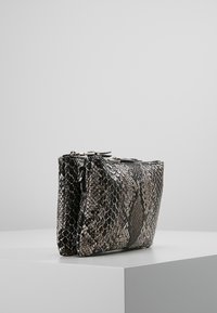 Borsa clutch compatta realizzata in materiale con motivo a serpente testurizzato in nero, grigio e beige. Presenta una chiusura con zip e una forma angolare.