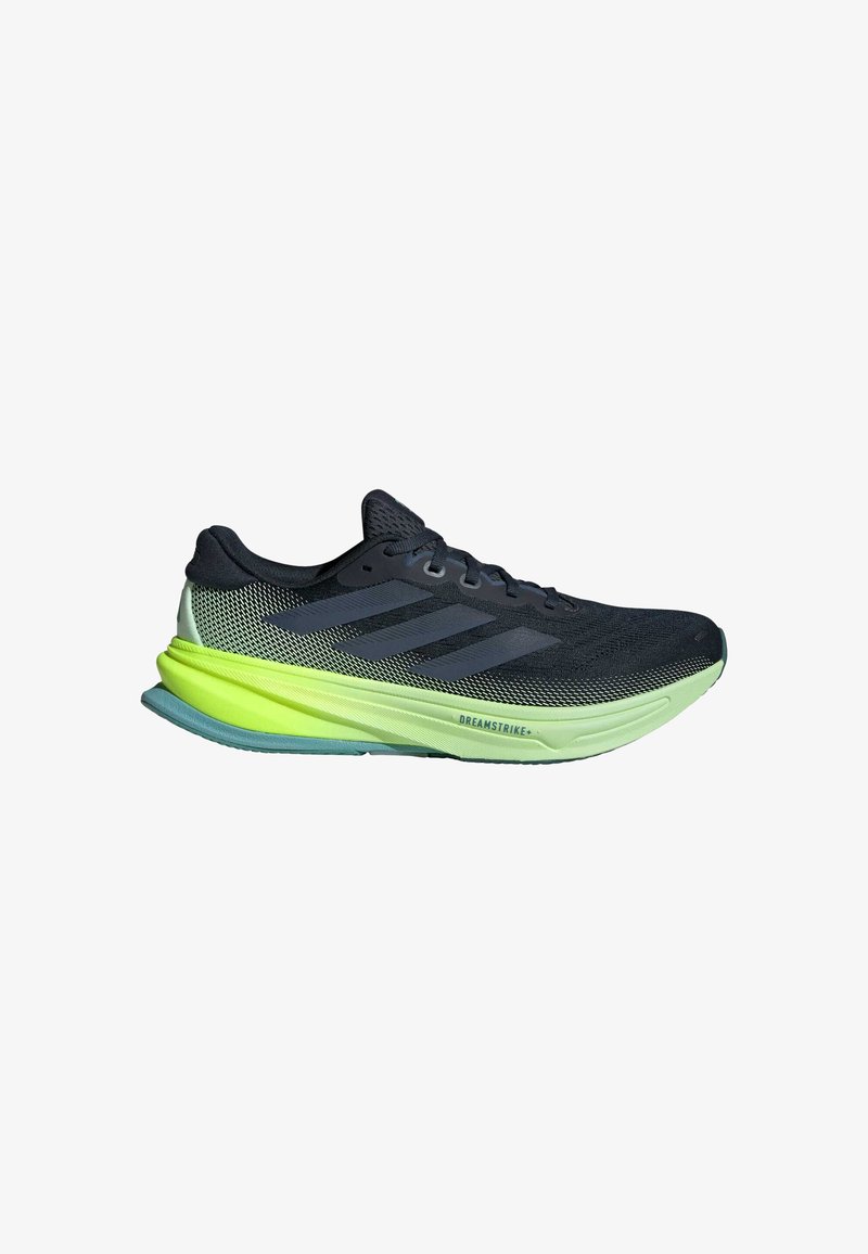 Running shoes with a black upper mesh, green accent midsole, and textured outsole. Features three dark stripes on the side.