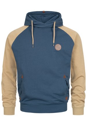 Huvtröja med blå kropp och beige ärmar, med en texturerad logotypapplikation, dragsko, kängurufickor och triangulära detaljer.