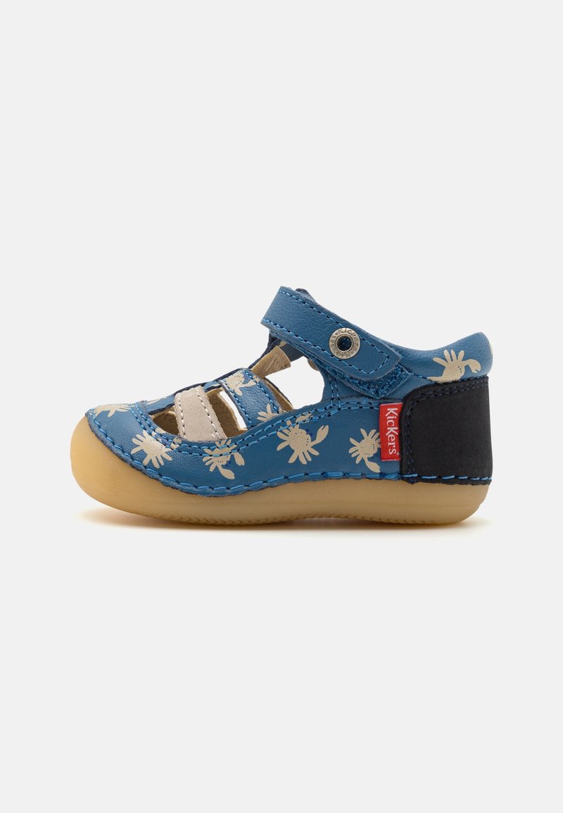 Sandale pour enfants en cuir bleu avec semelle en caoutchouc, design découpé et motifs de crabes crème. Comprend une sangle ajustable et un talon noir contrastant.
