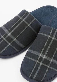 Granatowe i szare kapcie w kratę wykonane z miękkiego materiału, z okrągłym czubkiem i wyściełanym wnętrzem dla wygody. Podeszwa antypoślizgowa.