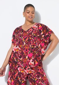 Top a V scollato e maniche corte con vivaci motivi floreali nei toni del rosa, rosso e arancione su uno sfondo scuro; vestibilità ampia e tessuto fluido.