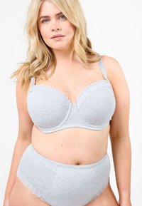 Vaaleanharmaa rintaliivien ja korkeavyötäröisten alushousujen setti, joka on valmistettu pehmeästä kankaasta. Setissä on valelaskostukset ja ei näkyviä kiinnikkeitä. Sileä tekstuuri.