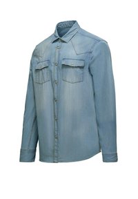 Camicia di jeans azzurro chiaro con maniche lunghe, chiusura a bottoni, due tasche sul petto e dettagli di cucitura visibili. Design semplice e informale.