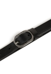 Cinturón de cuero negro con una hebilla ovalada de metal plateado con "VANS" grabado y múltiples agujeros para ajustar el tamaño. Textura suave en general.