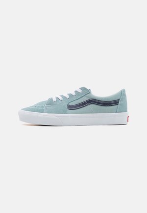 Zapatillas de ante azul claro con cordones blancos, raya lateral oscura en contraste y suela de goma. Presenta acentos cosidos y un branding minimalista.