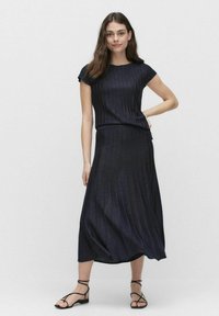 Dark navy, knee-length dress with a fitted top and flowing skirt. Made from ribbed fabric with a subtle sheen. Short sleeves and relaxed fit.